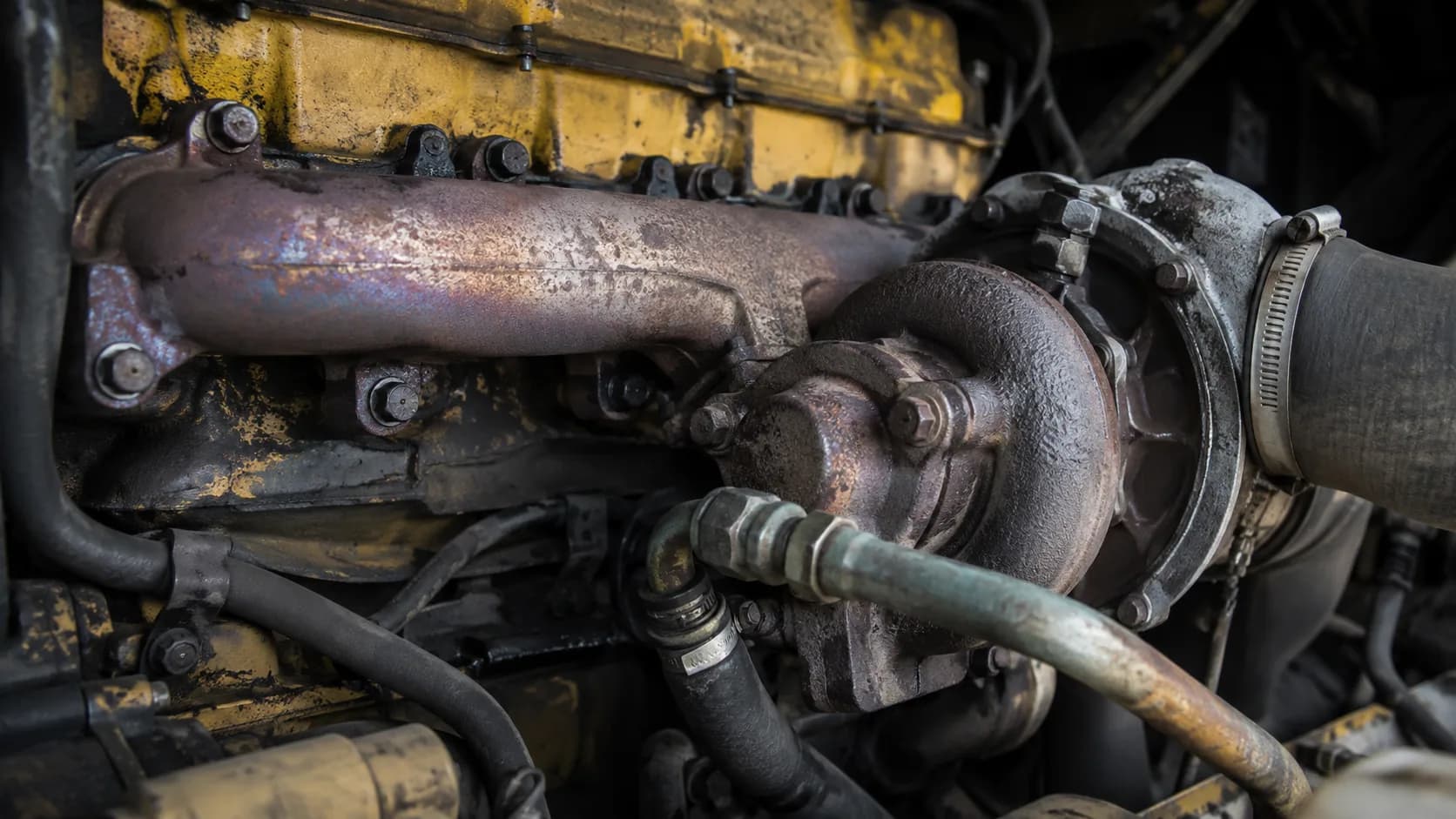 Heat-tinted manifold, chipped paint, hoses everywhere. Up close, a hard-working Cat engine wears its miles on the outside.