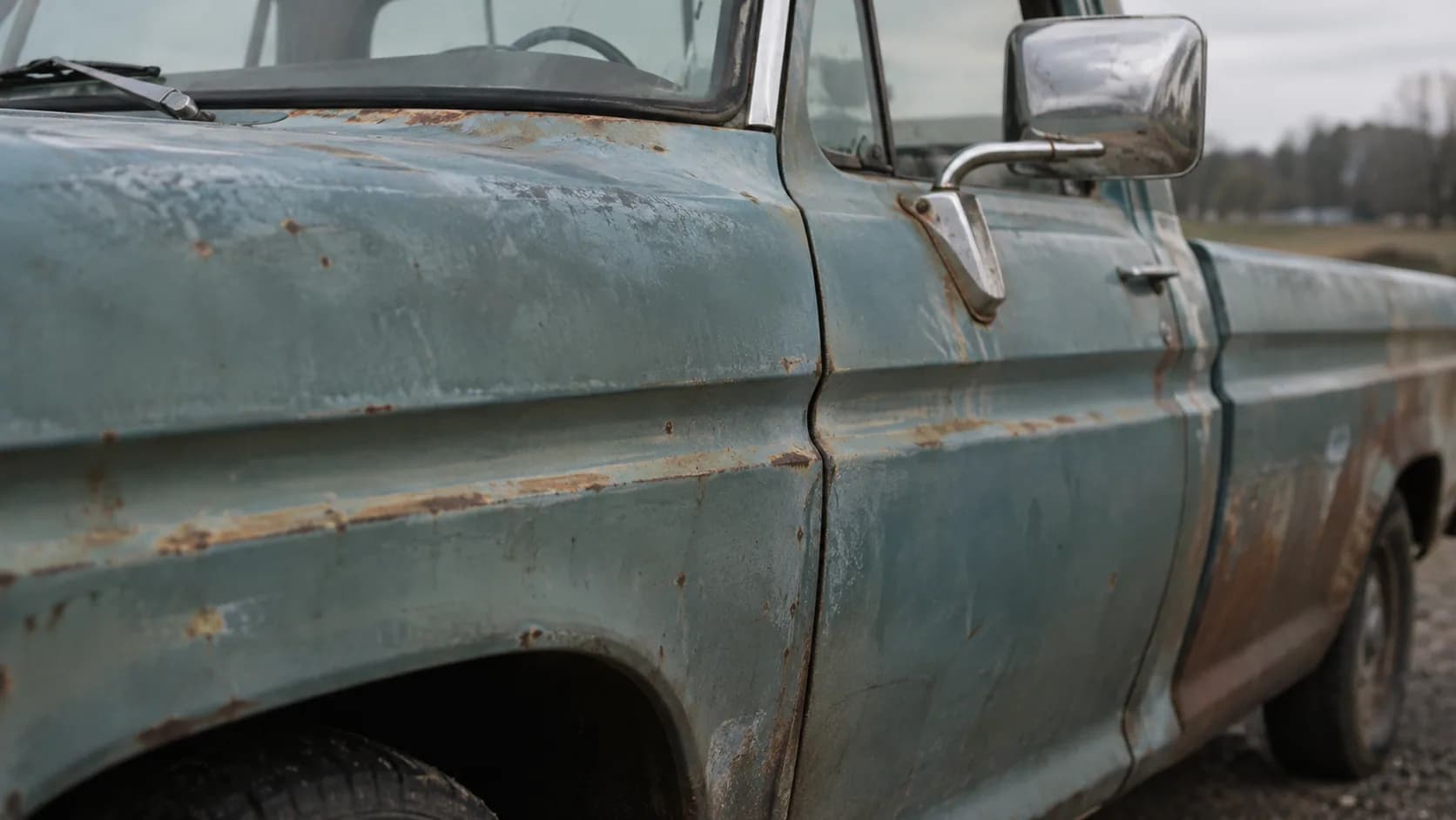 Faded blue paint, rust along the body line and a chrome mirror still hanging on. Do you see a lost cause or a project worth saving?
